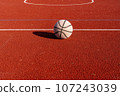 A well worn basketball ball on empty court 107243039