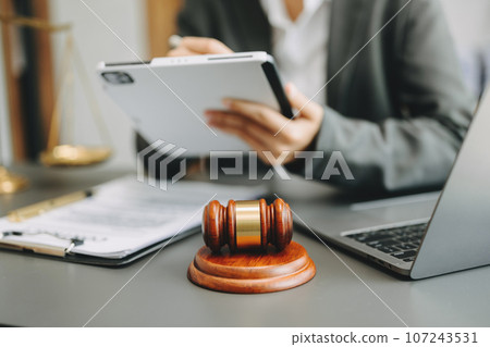 Male lawyer in the office with brass scale on wooden table. justice and law concept in morning light. Male lawyer in the office with brass scale on wooden table. justice and law concept in morning light. 107243531