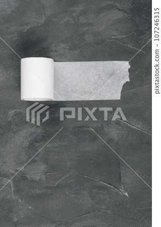 Roll of white tape lies on dark gray background. Elastic therapeutic tape-tape in cosmetology, beauty industry. Roll of white tape lies on dark gray background. Elastic therapeutic tape-tape in cosmetology, beauty industry. 107246315