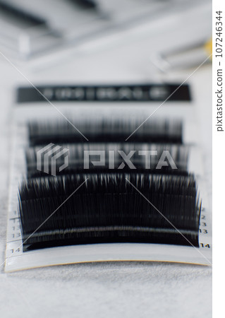 Group of different length, shape, thickness of eyelashes for extension on white background. Concept of beauty. Group of different length, shape, thickness of eyelashes for extension on white background. Concept of beauty. 107246344