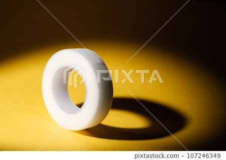 Elastic therapeutic tape- tape for cosmetology and medicine. Roll of white tape on yellow background. Beauty . MOCKUP. Elastic therapeutic tape- tape for cosmetology and medicine. Roll of white tape on yellow background. Beauty . MOCKUP. 107246349