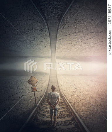 Infinity road concept with a man walking the railway to the parallel world above. Surreal and mysterious scene, adventure journey on the endless way 107246987