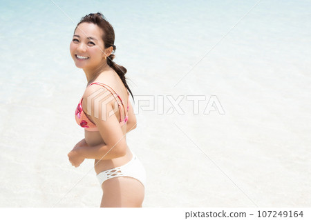 穿著比基尼的年輕女子在淺灘上微笑 穿著比基尼的年輕女子在淺灘上微笑 107249164