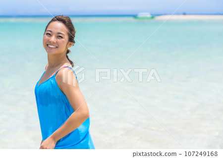 Young woman walking on a tropical beach Young woman walking on a tropical beach 107249168