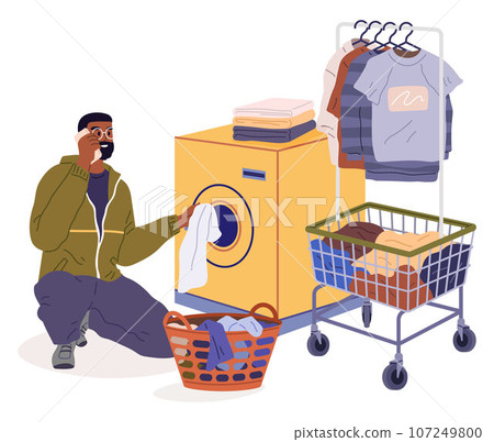 Man loading washing machine with clothes. Person putting linen into washers drum. Guy opening door of washingmachine for laundry. Male character in public laundry talking on phone. Household chores Man loading washing machine with clothes. Person putting linen into washers drum. Guy opening door of washingmachine for laundry. Male character in public laundry talking on phone. Household chores 107249800