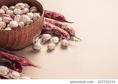 Cranberry beans. Fresh Organic Borlotti bean pods in bowl. Stylish modern food background. Magenta color. Creative foodstuff image. Grocery, dietary backdrop. Advertising, trendy magazine publication. Cranberry beans. Fresh Organic Borlotti bean pods in bowl. Stylish modern food background. Magenta color. Creative foodstuff image. Grocery, dietary backdrop. Advertising, trendy magazine publication. 107250154