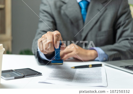 Signing approval record documents stamp confirmation occupation signature. businessman hand stamping finance paper work concept. 107250332