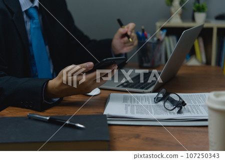business analysis marketing financial and data insights. Hand man holding mobile smartphone on desk. business analysis marketing financial and data insights. Hand man holding mobile smartphone on desk. 107250343