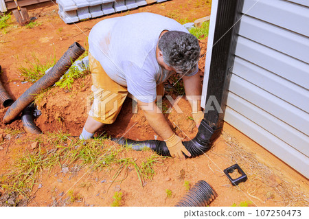 Flexible gutter extension drainage pipe connector downspout installation with water draining down 107250473