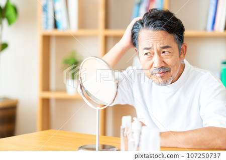 一位中年男子正在關心自己的頭髮。 107250737