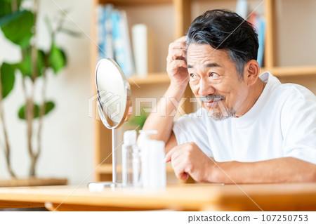 A middle-aged man who is concerned about his hair. A middle-aged man who is concerned about his hair. 107250753