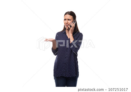 a young woman with black hair dressed in a blue blouse speaks with surprise on the phone a young woman with black hair dressed in a blue blouse speaks with surprise on the phone 107251017