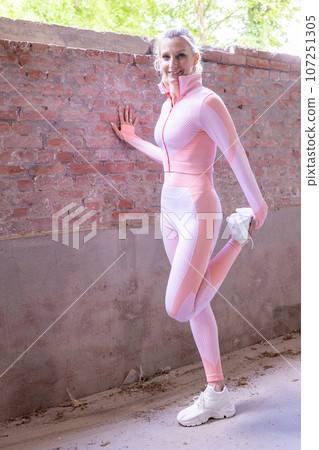 Morning Stretch Routine: Fit Blonde Woman in Pink Sportswear Morning Stretch Routine: Fit Blonde Woman in Pink Sportswear 107251305