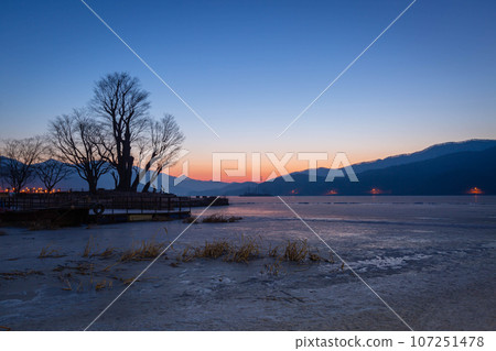 Frozen lake in South Korea in winter and big trees in the background at Dumulmeori, Yangpyeong, South Korea. Frozen lake in South Korea in winter and big trees in the background at Dumulmeori, Yangpyeong, South Korea. 107251478