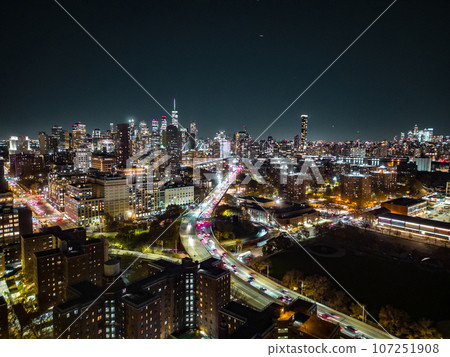 Night panoramic shot of modern metropolis with illuminated skyscrapers and busy highway. New York City, USA 107251908