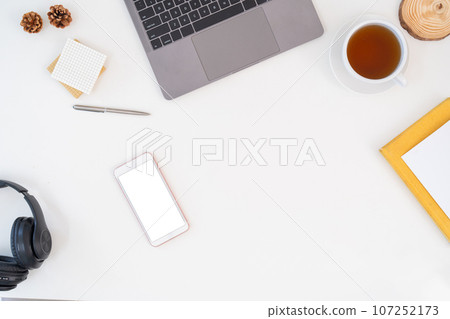 Top view above of white office desk table with keyboard computer, notebook and coffee cup with equipment other office supplies. business and lifestyle concept with blank copy space 107252173