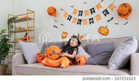Cute little child girl with balloon. Happy family preparing for Halloween Cute little child girl with balloon. Happy family preparing for Halloween 107252223