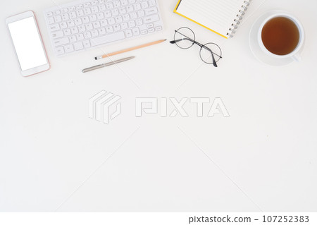 Top view above of white office desk table with keyboard notebook and coffee cup with equipment other office supplies. business and lifestyle concept with blank copy space 107252383