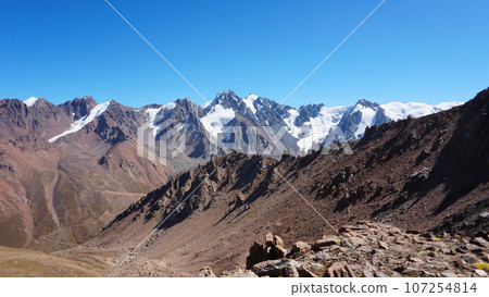 Rocky pass with a view of the snowy mountains Rocky pass with a view of the snowy mountains 107254814