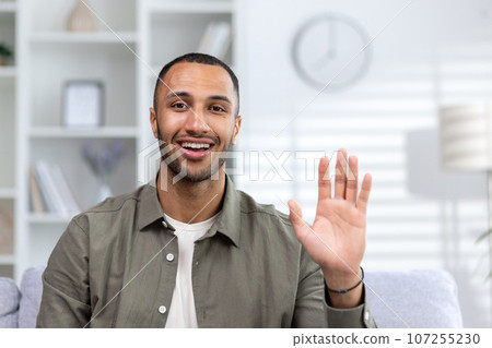 Portrait of a young African American male teacher. a business coach who greets and talks via video link to the camera from home. Portrait of a young African American male teacher. a business coach who greets and talks via video link to the camera from home. 107255230