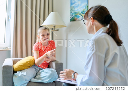 Child family psychology, female therapist talking to girl child 107255252