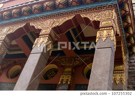fragment of the facade of a Buddhist datsan Gunzechoinei building with traditional elements 107255302