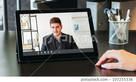 Video recruiting. Virtual chat. Confident man applicant on laptop screen speaking at online interview to manager business woman hand at home office workplace. 107255336