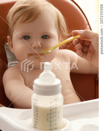 Grimy child eats with hands sitting on table at Grimy child eats with hands sitting on table at 107255508
