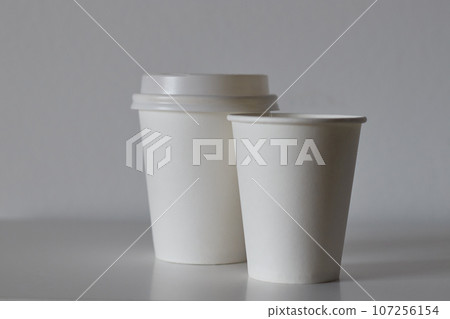 two white paper cups on table, mockup for design two white paper cups on table, mockup for design 107256154