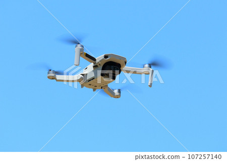 Aerial shooting site with a drone flying in the blue sky 107257140