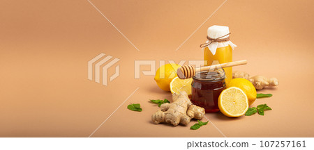 Composition with detox drink, sea buckthorn berries, lemons, mint, ginger, honey in glass jar. Food for immunity stimulation and against flu. Healthy natural remedies to boost immune system Composition with detox drink, sea buckthorn berries, lemons, mint, ginger, honey in glass jar. Food for immunity stimulation and against flu. Healthy natural remedies to boost immune system 107257161