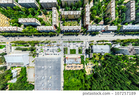 Aerial city view with crossroads and roads, houses, buildings, parks and parking lots. Sunny summer panoramic image Aerial city view with crossroads and roads, houses, buildings, parks and parking lots. Sunny summer panoramic image 107257189
