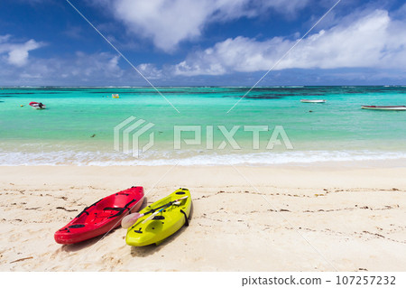 Seychelles beach landscape with colorful plastic kayaks Seychelles beach landscape with colorful plastic kayaks 107257232