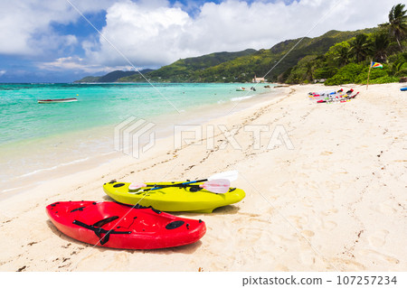 Seychelles beach view. Colorful plastic kayaks Seychelles beach view. Colorful plastic kayaks 107257234
