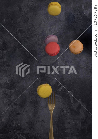 French macarons flying in the air on black background. Levitation 107257395