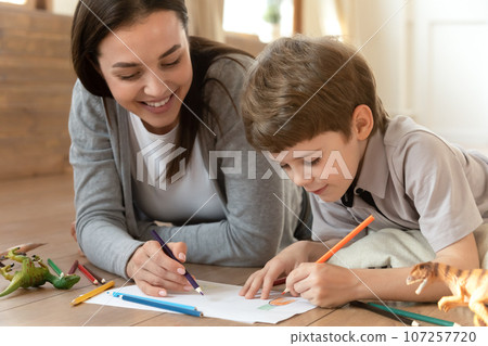 Close up happy mother and little son drawing pencils together Close up happy mother and little son drawing pencils together 107257720