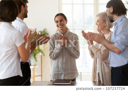 Staff encouraging mixed-race newcomer employee at meeting 107257724