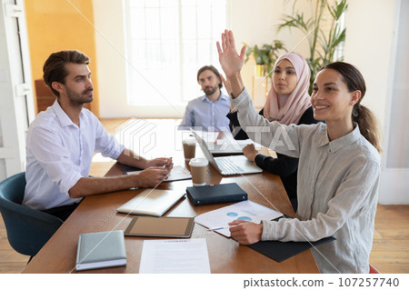 Biracial and arab women raising hand asking question at seminar 107257740