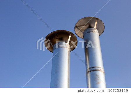 Metal chimney pipe on the roof of house Metal chimney pipe on the roof of house 107258139