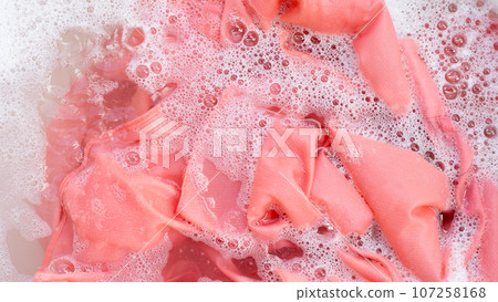 Top view of formal shirts soak in powder detergent water dissolution. Laundry concept Top view of formal shirts soak in powder detergent water dissolution. Laundry concept 107258168