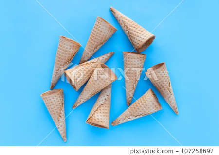Empty ice cream cone on blue background. 107258692