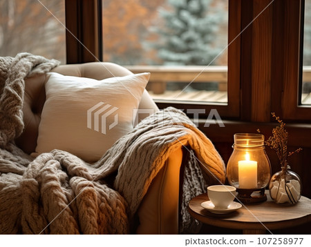 Cozy winter home interior with knitted blankets and pillows, holiday country house in wood, warm fire and afternoon daylight Cozy winter home interior with knitted blankets and pillows, holiday country house in wood, warm fire and afternoon daylight 107258977