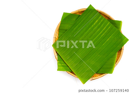 Banana leaves in bamboo weave plate on white background. 107259140