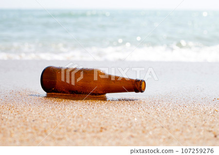 Glass bottle on the beach 107259276