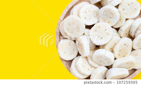 Banana slices on yellow background. 107259305