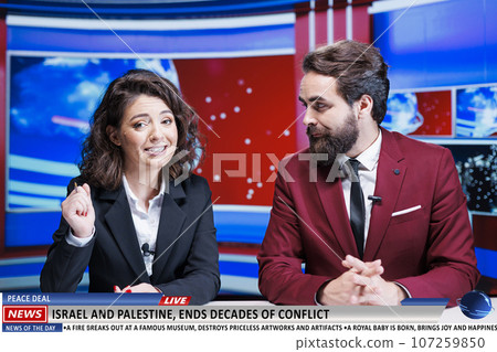 News anchors announce end of long war between israel and palestine, celebrating peace treaty signed by nations fighting for decades. Man and woman journalists on talk show in newsroom. 107259850