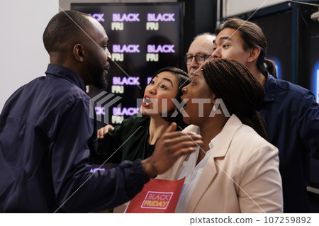 Mad angry diverse people shoppers eager to start Black Friday shopping, arguing with security guy, asking him to open store. Customers tired of waiting in line during seasonal sales Mad angry diverse people shoppers eager to start Black Friday shopping, arguing with security guy, asking him to open store. Customers tired of waiting in line during seasonal sales 107259892
