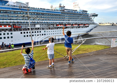 Children watching off a large cruise ship from the pier Children watching off a large cruise ship from the pier 107260013
