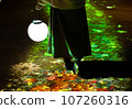 Rear view of a woman holding a lamp in the autumn park 107260316