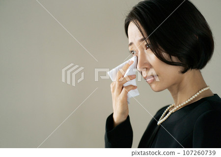 Photo of a woman crying at a funeral 107260739